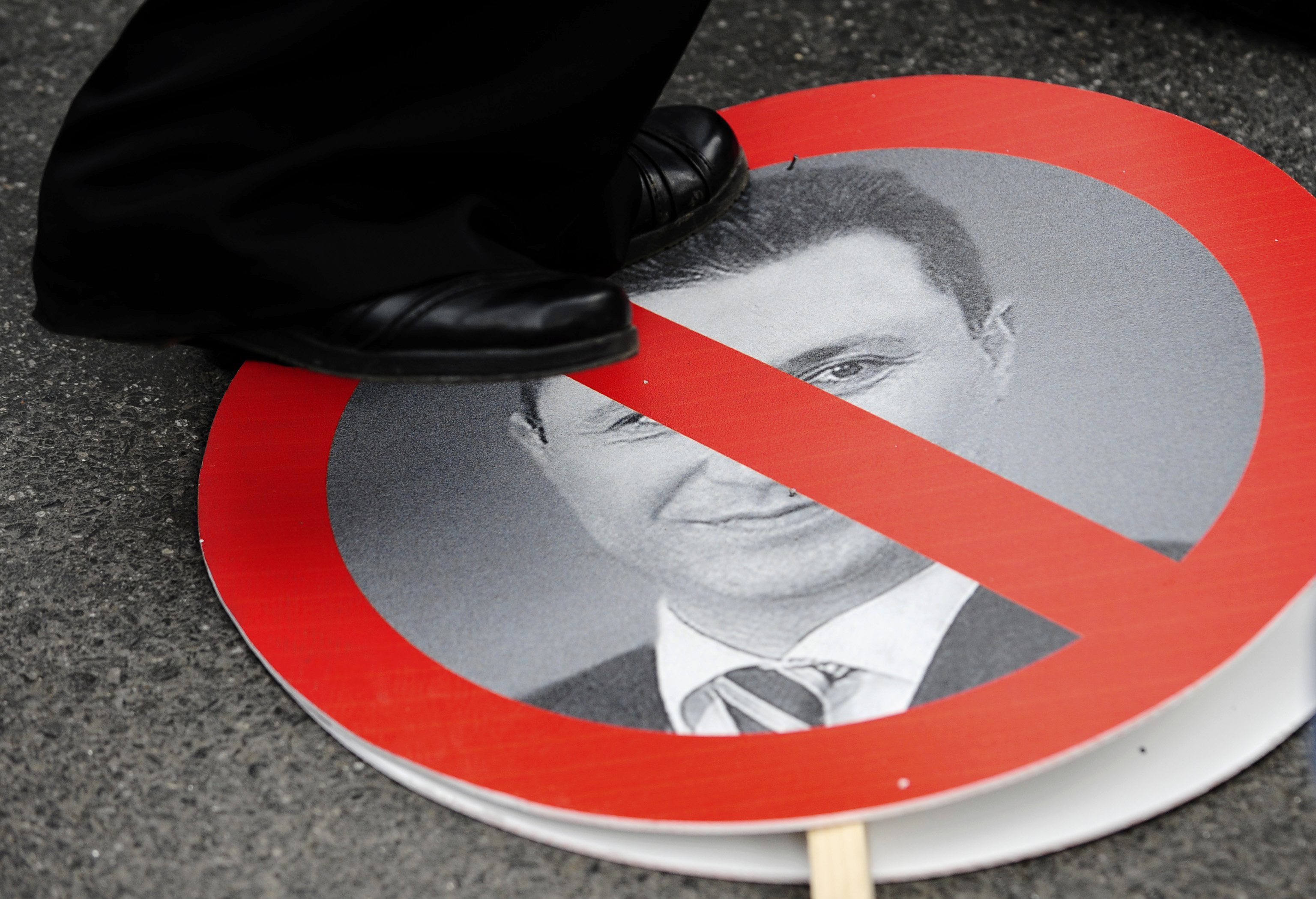 A protester steps on a sign with a portrait of Macedonian Prime Minister Nikola Gruevski during an anti-government demonstration in Skopje, Macedonia, May 17, 2015. Tens of thousands of protesters took to the streets of Macedonia's capital on Sunday, waving Macedonian and Albanian flags in a dramatic display of ethnic unity against a government on the ropes after months of damaging wire-tap revelations. REUTERS/Ognen Teofilovski