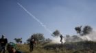 A Palestinian protester returns a tear gas canister fired by Israeli troops during clashes following a rally marking Nakba Da