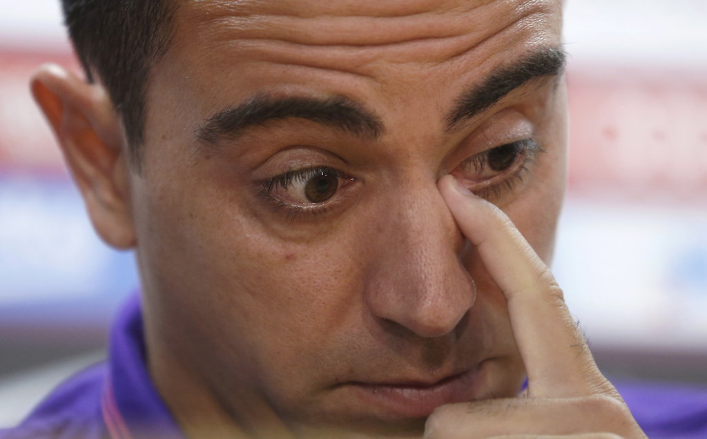 FC Barcelona's Xavi Hernandez wipes his eye during a press conference at the Sports Center FC Barcelona Joan Gamper in San Joan Despi, Spain, Thursday, May 21, 2015. Barcelona midfielder Xavi Hernandez says he will leave the Catalan club after 17 trophy-laden seasons in which he set club records for appearances and titles won. The 35-year-old Xavi, who has played 764 matches for Barcelona, says he will cut his contract short by one year and leave after this season to go play for Qatari club Al-Sadd on a two-year contract. (AP Photo/Manu Fernandez)