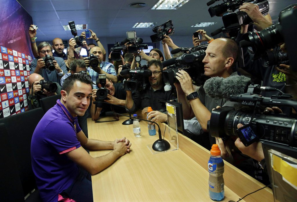 epa04760121 FC Barcelona's captain Xavi Hernandez (L) attends a press conference to announces his departure from Spanish champions FC Barcelona at the end of the season in Barcelona, northeastern Spain, 21 May 2015. Xavi will join Qatar's Al-Sadd Sports Club after playing 17 seasons for Barca. EPA/ALBERTO ESTEVEZ
