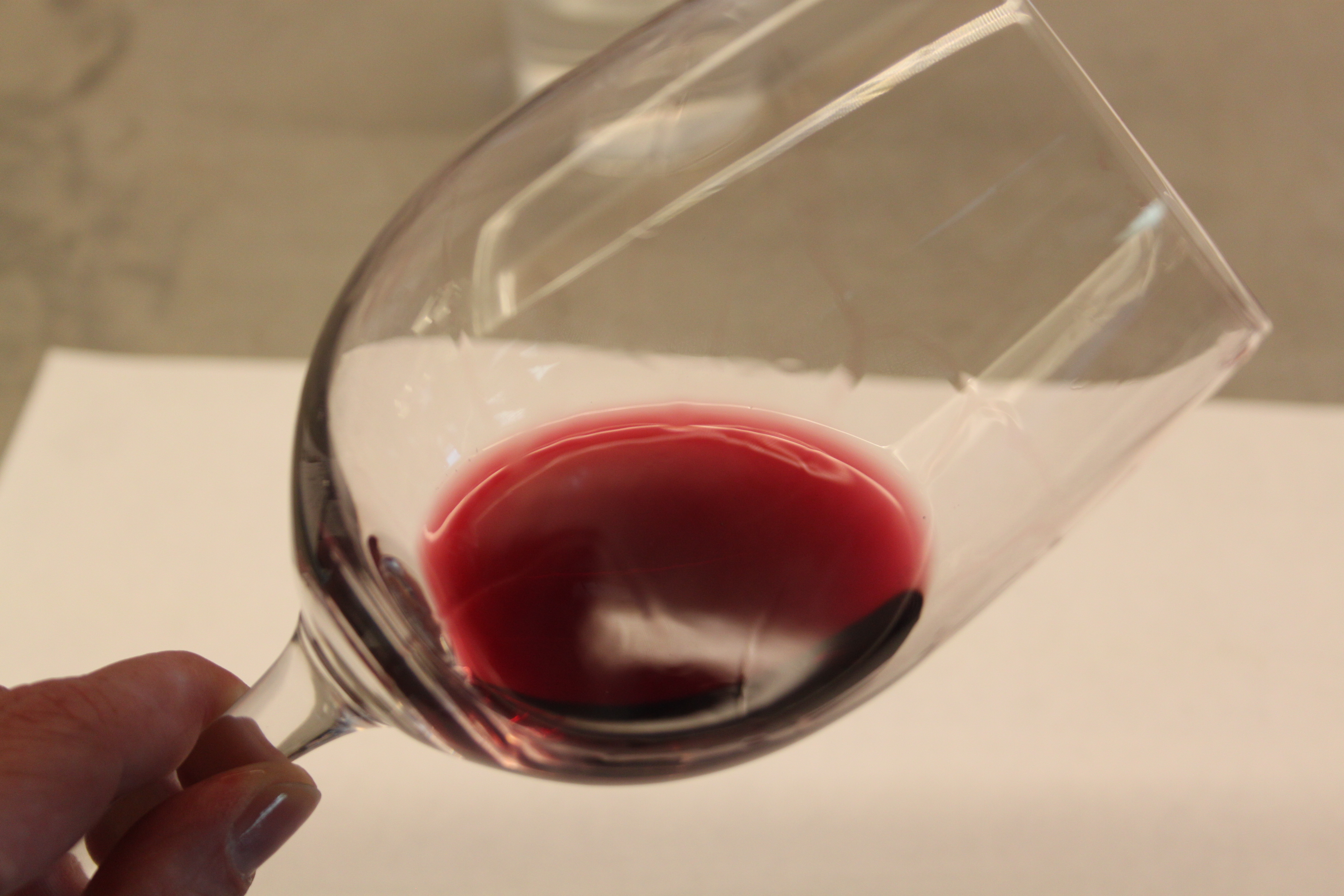 Das Glas schräg und gegen eine helle Oberfläche halten: so stellt man fest, welche Farbe ein Wein hat.