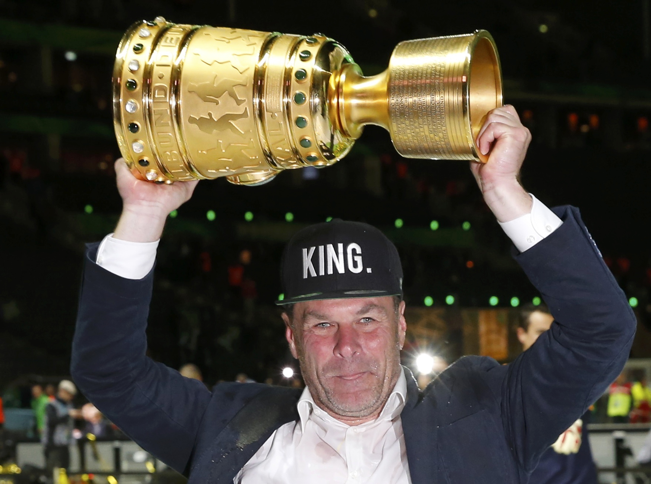 VfL Wolfsburg's coach Dieter Hecking celebrates with the trophy after their German Cup (DFB Pokal) final soccer match against Borussia Dortmund in Berlin, Germany, May 30, 2015. REUTERS/Fabrizio Bensch DFB RULES PROHIBIT USE IN MMS SERVICES VIA HANDHELD DEVICES UNTIL TWO HOURS AFTER A MATCH AND ANY USAGE ON INTERNET OR ONLINE MEDIA SIMULATING VIDEO FOOTAGE DURING THE MATCH.