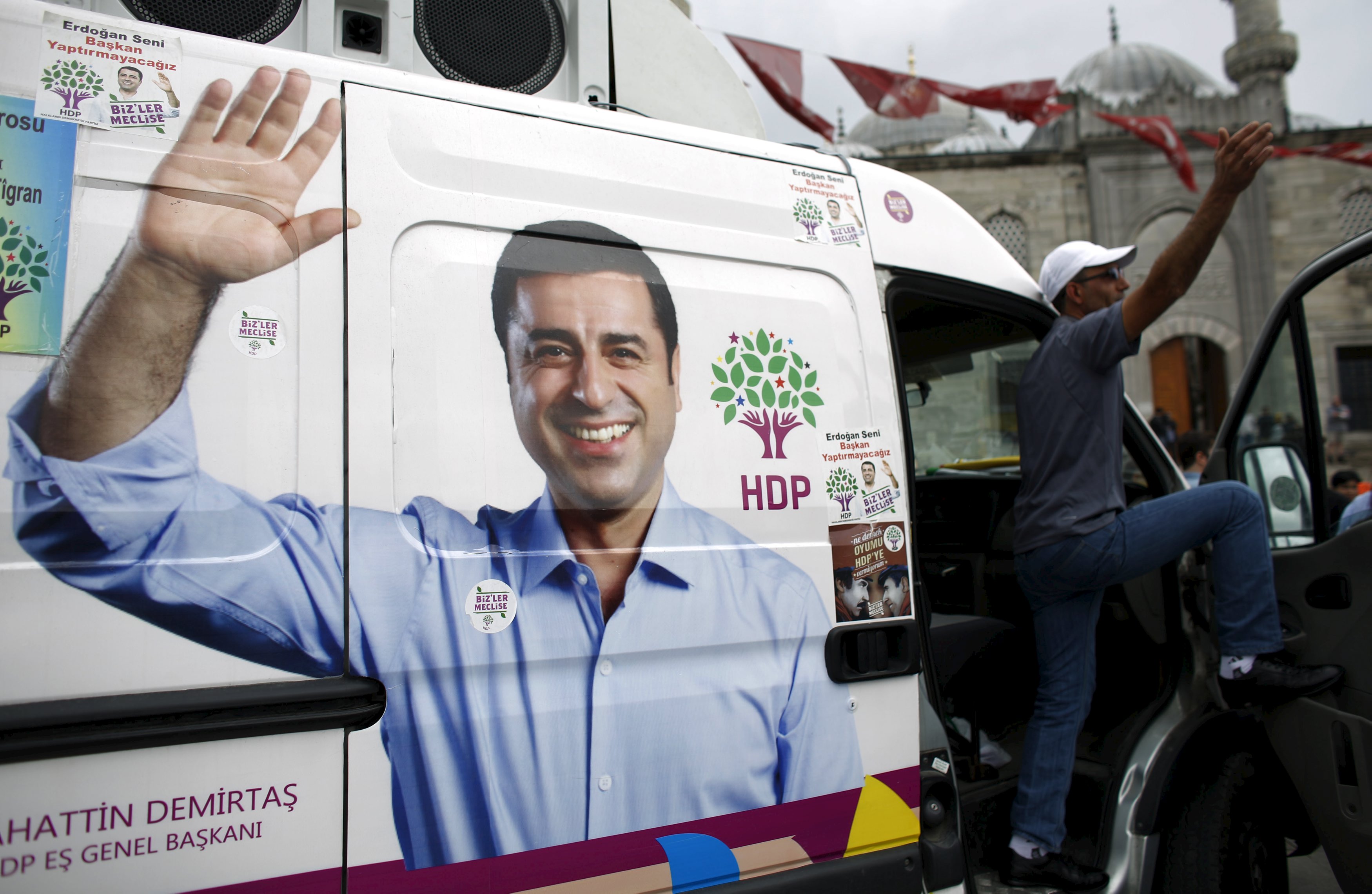 A supporter of pro-Kurdish People's Democratic Party (HDP) stands on an election campaign minibus with a picture of the party's co-chair Selahattin Demirtas on it, in Istanbul, Turkey, May 28, 2015. Turkey's Pro-Kurdish People's Democratic Party (HDP) said on Wednesday June elections would lack legitimacy if a threshold for parliamentary representation deprived it of representation, but it would remain a partner in peace talks with militants. The fate of the HDP, which hopes to cross the 10 percent national vote threshold to enter parliament on June 7, will be critical not just for the Kurdish minority but also for the political future of President Tayyip Erdogan. REUTERS/Murad Sezer