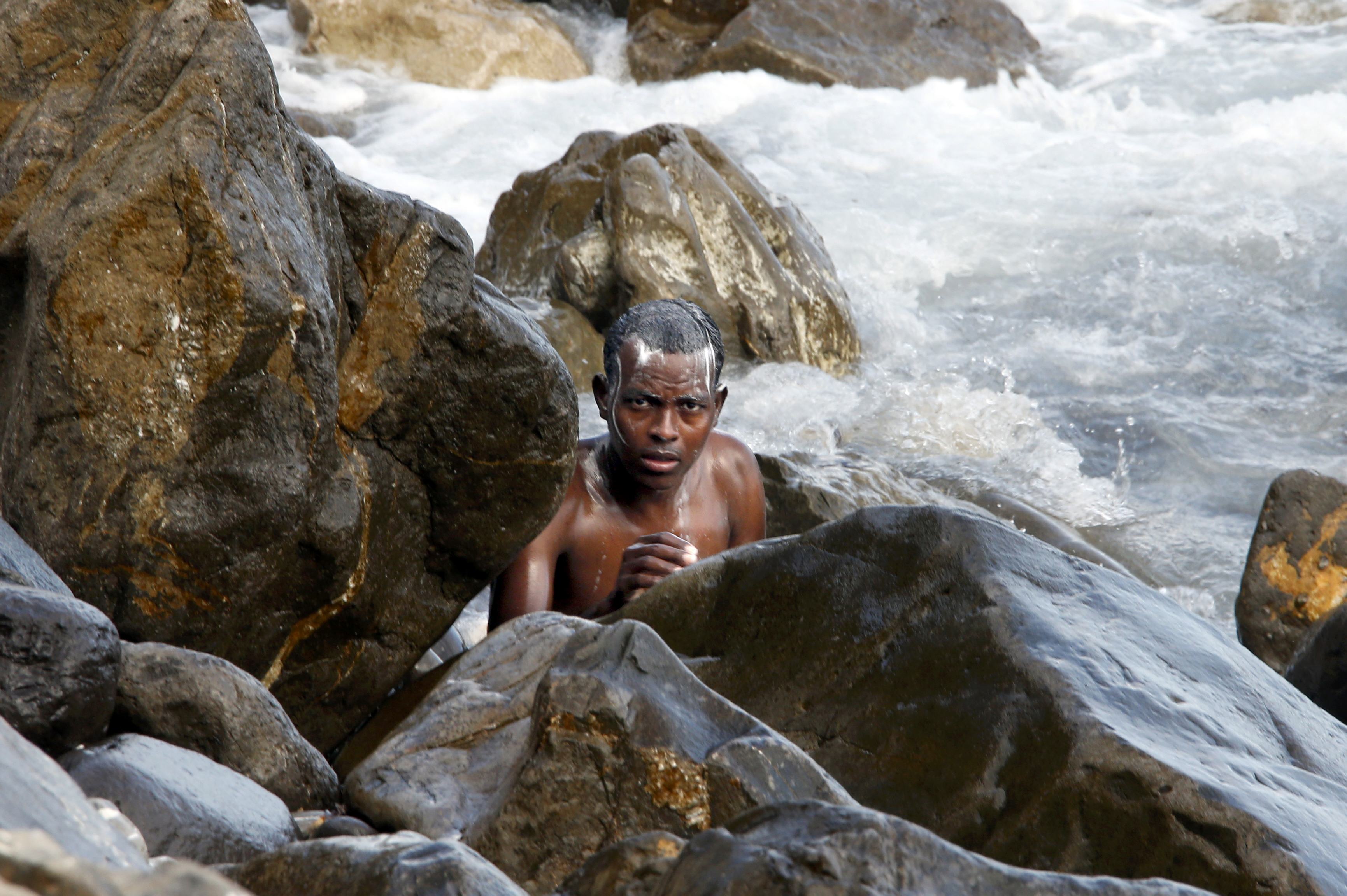 A migrant uses soap to bathe in the sea at the Saint Ludovic border crossing on the Mediterranean Sea between Vintimille, Italy and Menton, France, June 14, 2015. On Saturday, some 200 migrants, principally from Eritrea and Sudan who attempted to cross the border, were blocked by Italian police and French gendarmes. REUTERS/Eric Gaillard TPX IMAGES OF THE DAY
