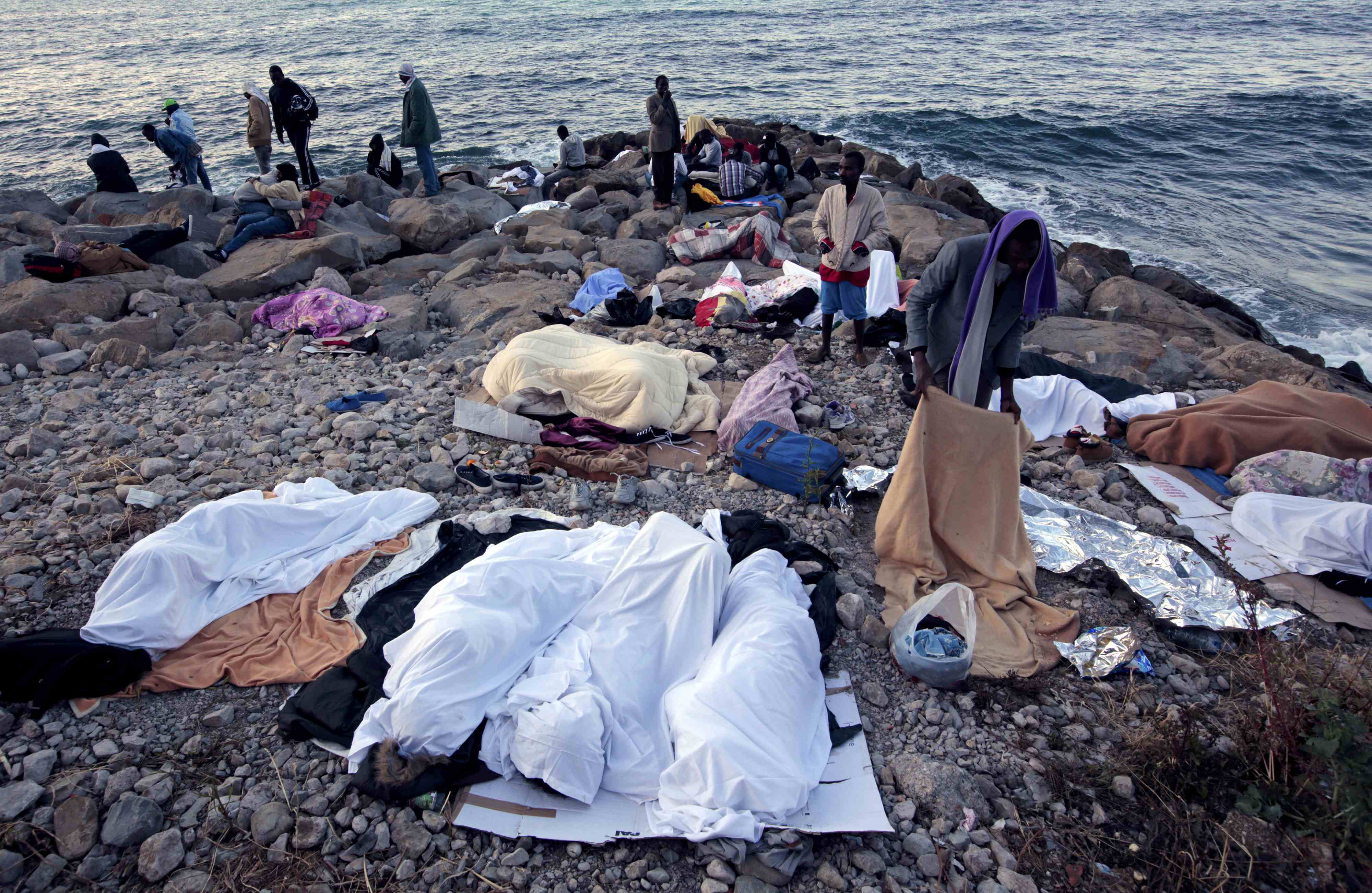 Migrants sleep on the rocks of the seawall at the Saint Ludovic border crossing on the Mediterranean Sea between Vintimille, Italy and Menton, France, June 15, 2015. On Saturday,some 200 migrants, principally from Eritrea and Sudan, attempted to cross the border from Italy and were blocked by Italian police and French gendarmes. REUTERS/Eric Gaillard TPX IMAGES OF THE DAY