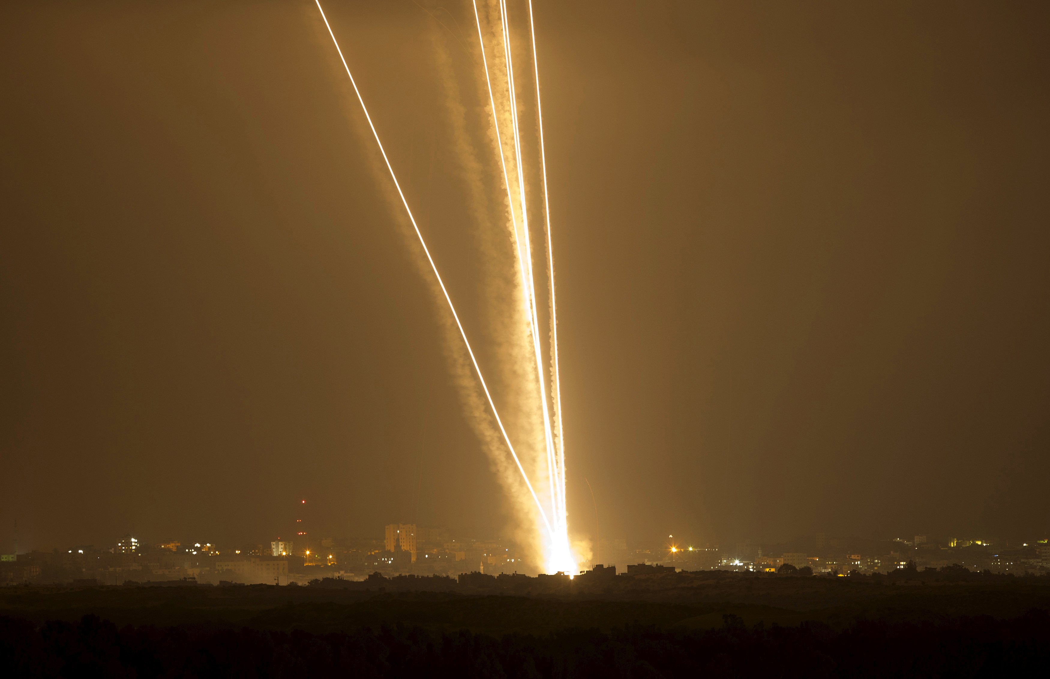 Light streaks and smoke trails are seen as rockets are launched from Gaza towards Israel in this July 23, 2014 file photo. Israel disputed on June 22, 2015 the findings of a U.N. report that it may have committed war crimes in the 2014 Gaza conflict, saying its forces acted 