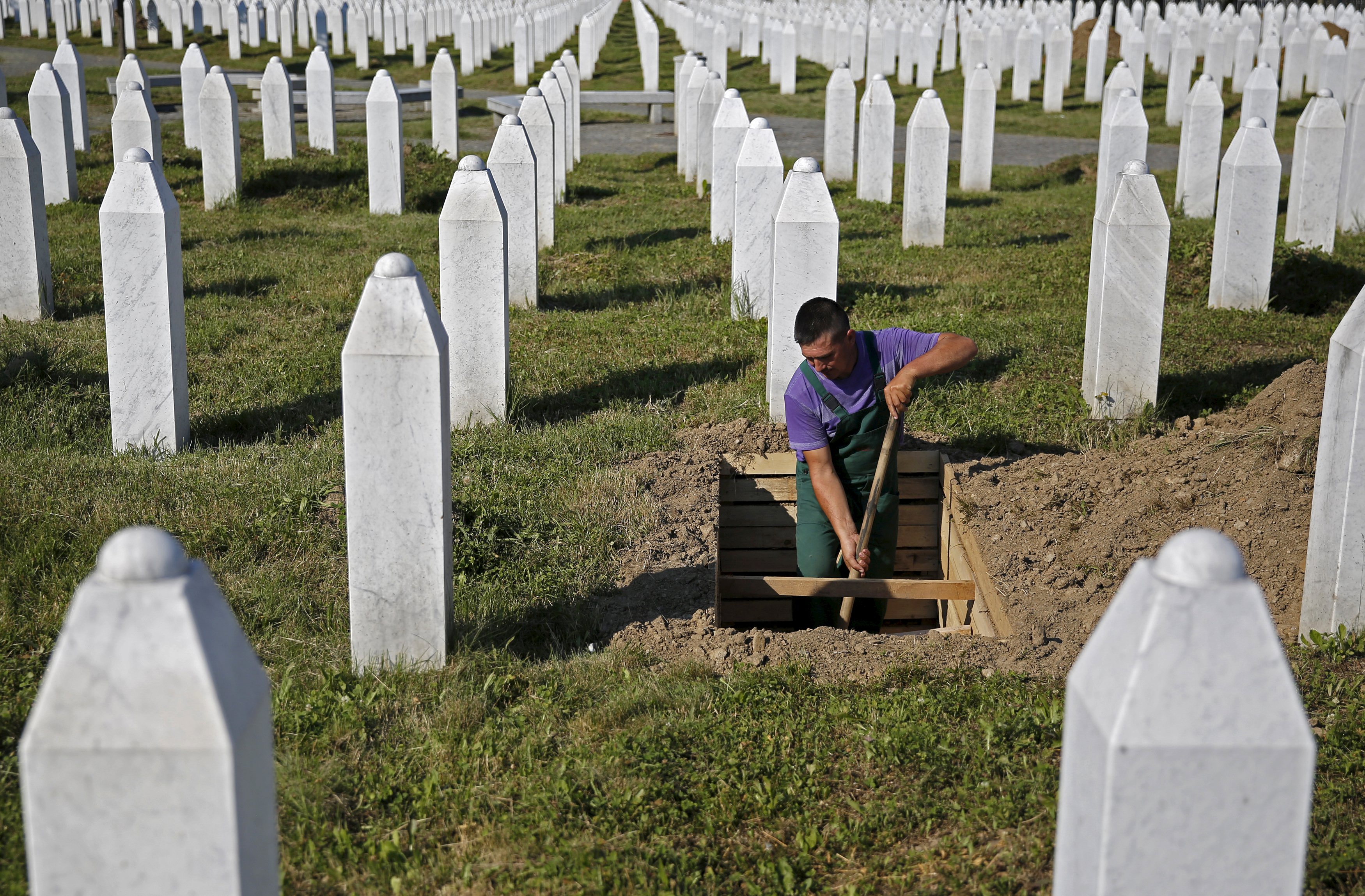 A worker digs graves at a memorial centre for Srebrenica Massacre victims in Potocari July 5, 2015. Tens of thousands of family members, foreign dignitaries and guests are expected to attend a ceremony in Srebrenica on July 11 marking the 20th anniversary of the massacre in which Bosnian Serb forces commanded by Ratko Mladic killed up to 8,000 Muslim men and boys. Nearly 136 identified victims will be buried at a memorial cemetery during the ceremony, their bodies found in some 60 mass graves around the town. REUTERS/Dado Ruvic