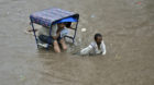 A rickshaw puller transports a commuter through a flooded road after heavy rainfall in Mathura, India, July 10, 2015. Good ra