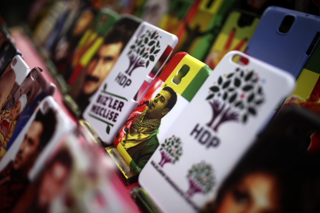 A mobile phone cover with a picture of Selahattin Demirtas, co-chair of the pro-Kurdish Peoples' Democratic Party (HDP), and cases with the party's logo are offered for sale among others at a market in Diyarbakir, the main city in Turkey's predominantly Kurdish southeast, Tuesday, June 9, 2015. The biggest change from Turkey's previous parliament is the ascendancy of the pro-Kurdish People's Democratic Party, (DHP), a socially liberal force rooted in the Kurdish nationalism of Turkey's southeast. It attracted more than 12 percent of votes, breaching the minimum threshold of 10 percent. (AP Photo/Emre Tazegul)