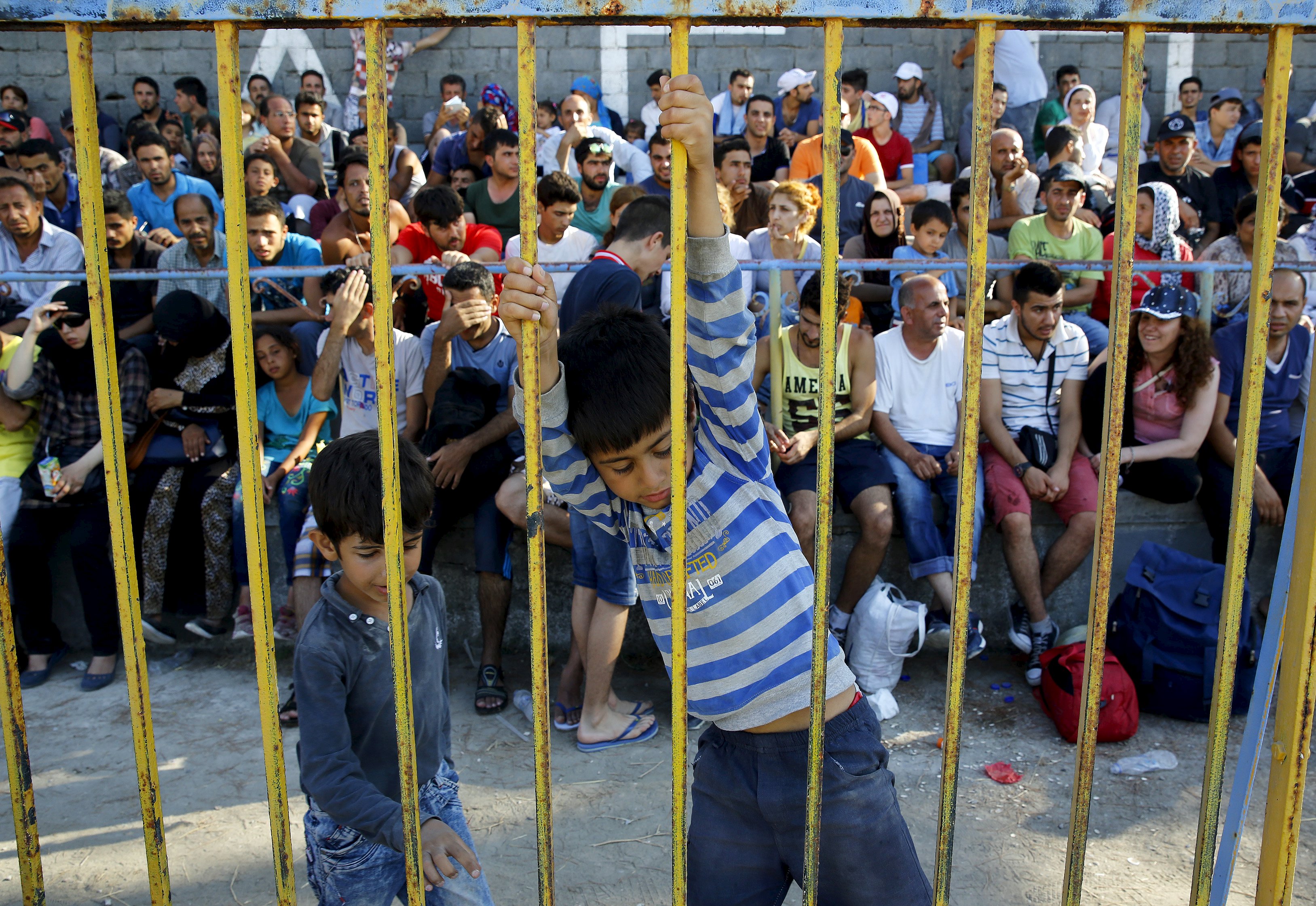 Syrian refugees pack the stands inside the national stadium on the Greek island of Kos August 11, 2015. Local authorities are struggling to cope with the increasing numbers of migrants and refugees arriving in dinghies from the nearby Turkish coast. Police ushered most migrants into the stadium, packing the stands, in order to speed up the registration process. Some migrants set up tents while police stood guard in riot gear. REUTERS/ Yannis Behrakis