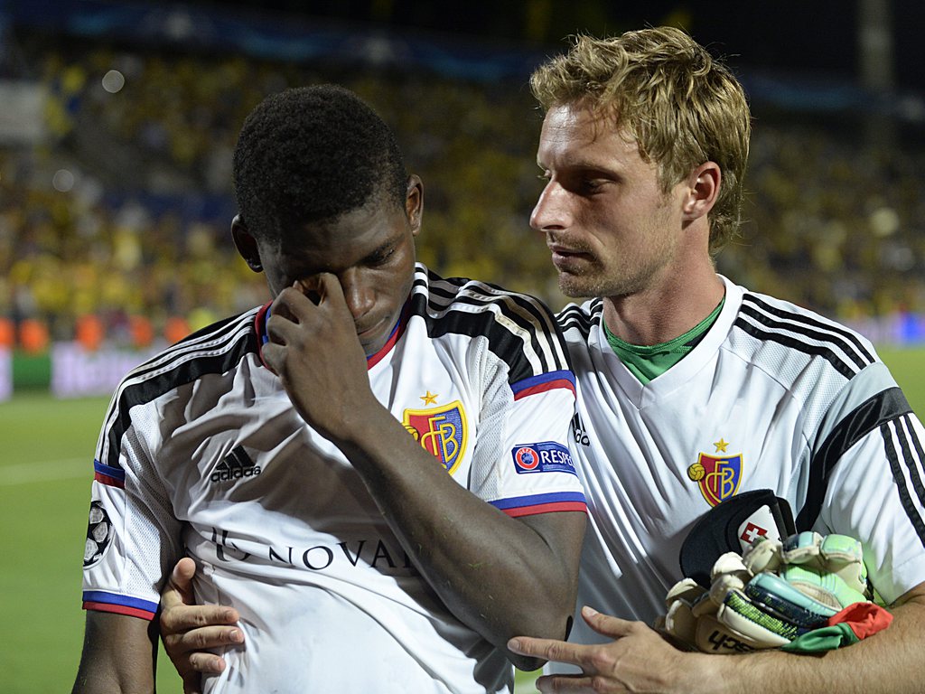 epa04898132 Basel's Breel Embolo (L) is comforted by team mate Germano Vailati after the UEFA Champions League play-off round second leg soccer match between Maccabi Tel Aviv FC and FC Basel 1893 at the Bloomfield stadium in Tel Aviv, Israel, 25 August 2015. Maccabi Tel Aviv won on away goals. EPA/GEORGIOS KEFALAS