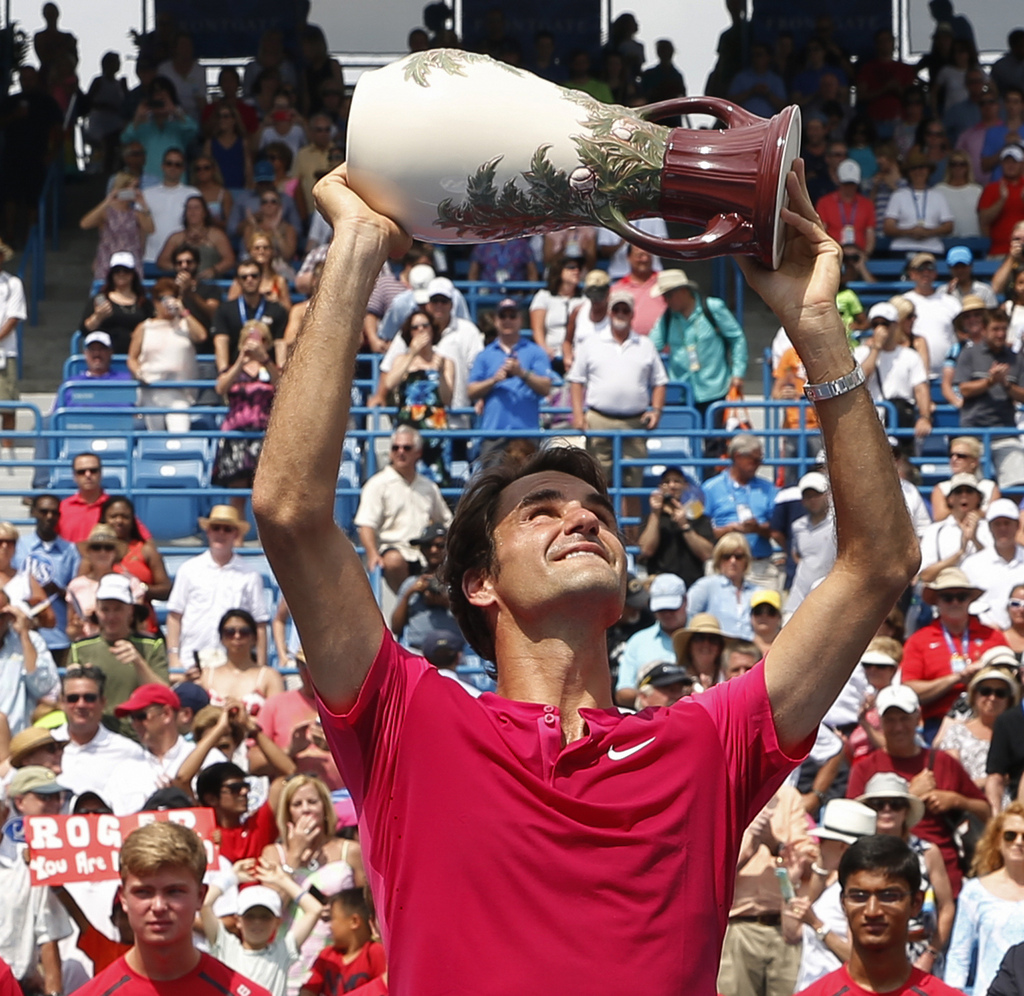 Roger Federer, of Switzerland, holds the Rookwood Cup after winning the men's final against Novak Djokovic, of Serbia, at the Western & Southern Open tennis tournament, Sunday, Aug. 23, 2015, in Mason, Ohio. Federer defeated Djokovic 7-6 (1), 6-3. (AP Photo/John Minchillo)