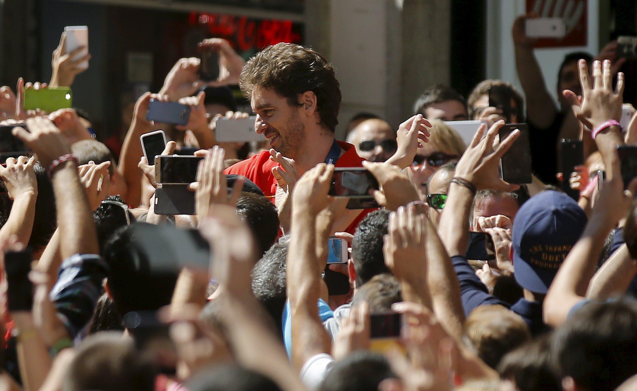 Spain's basketball player Pau Gasol walks through a crowd holding mobile phones after his arrival for a celebration with fans the day after winning their EuroBasket 2015 final, during a ceremony in central Madrid, Spain, September 21, 2015. REUTERS/Andrea Comas