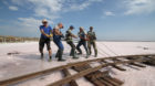 Workers lay rails across the bed of a drained area of a lake used for the production of salt at the Sasyk-Sivash lake near th