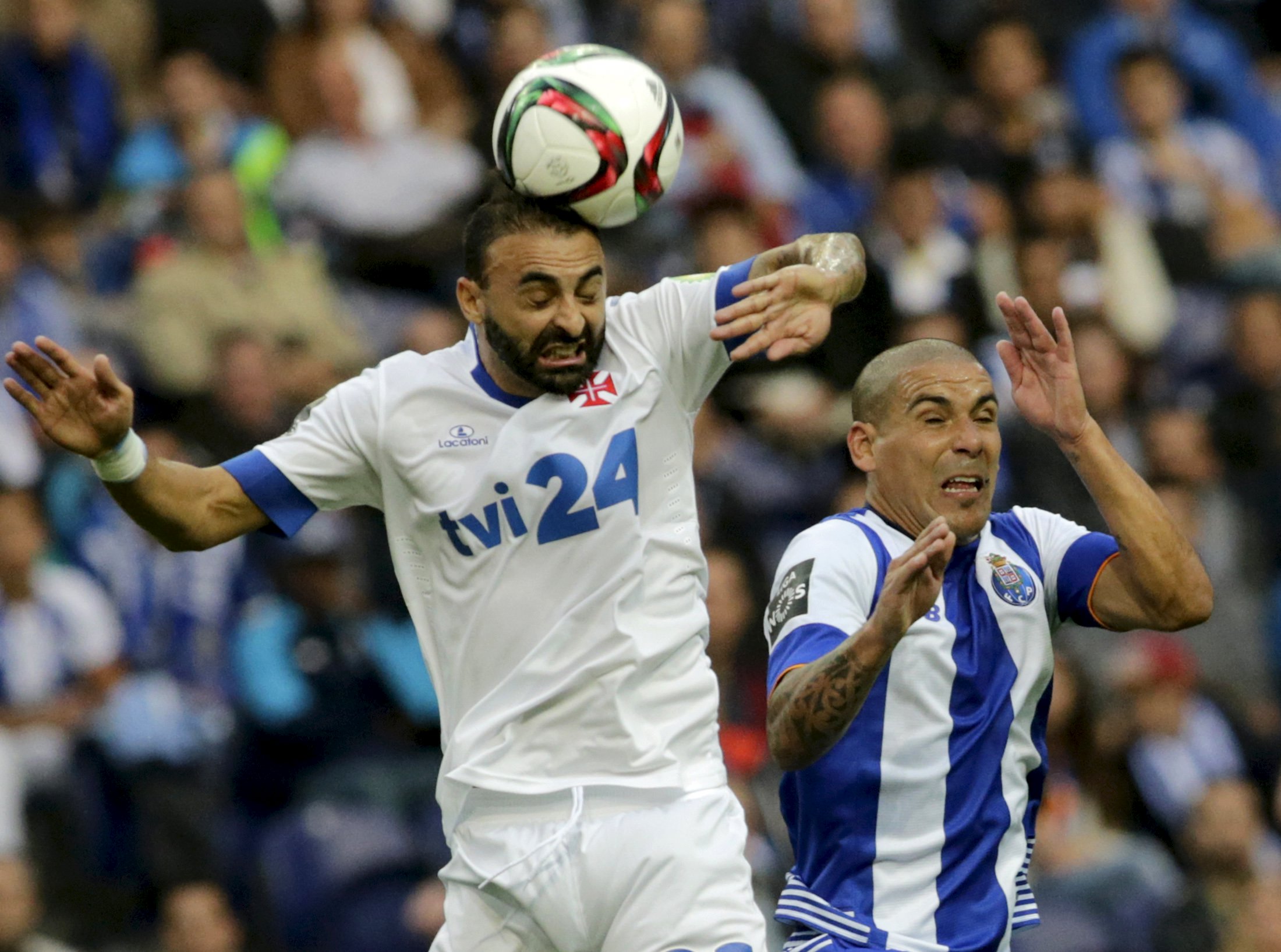 Porto's Maxi Pereira (R) jumps for the ball with Belenenses' Carlos Martins during their Portuguese Premier League soccer match at Dragao stadium in Porto, Portugal, October 4, 2015. REUTERS/Miguel Vidal