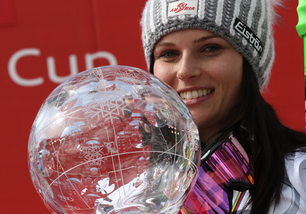 FILE - In this March 22, 2015 file photo Anna Fenninger of Austria poses for photographers as she holds the alpine skiing women's World Cup overall trophy at the World Cup finals in Meribel, France. The Austrian ski federation says Wednesday, Oct. 21, 2015, Fenninger has been hospitalized with an apparent left knee injury following a training crash, three days before the Alpine skiing season starts. (AP Photo/Armando Trovati, File)