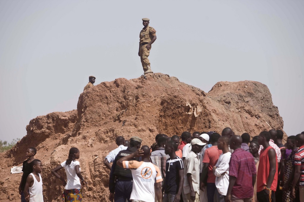 Exhumierung Sankara: Security forces, top, keep watch near the Dagnoen Cemetery, as the graves of thirteen people including Burkina Faso revolutionary leader Thomas Sankara, are exhumed on the outskirts of Ouagadougou, Burkina Faso, Monday, May 25, 2015. Sankara, a widely admired figure across Africa, was killed along with 12 others under unclear circumstances in the 1987 coup that brought his former best friend Blaise Compaore to power. (AP Photo/Theo Renaut)