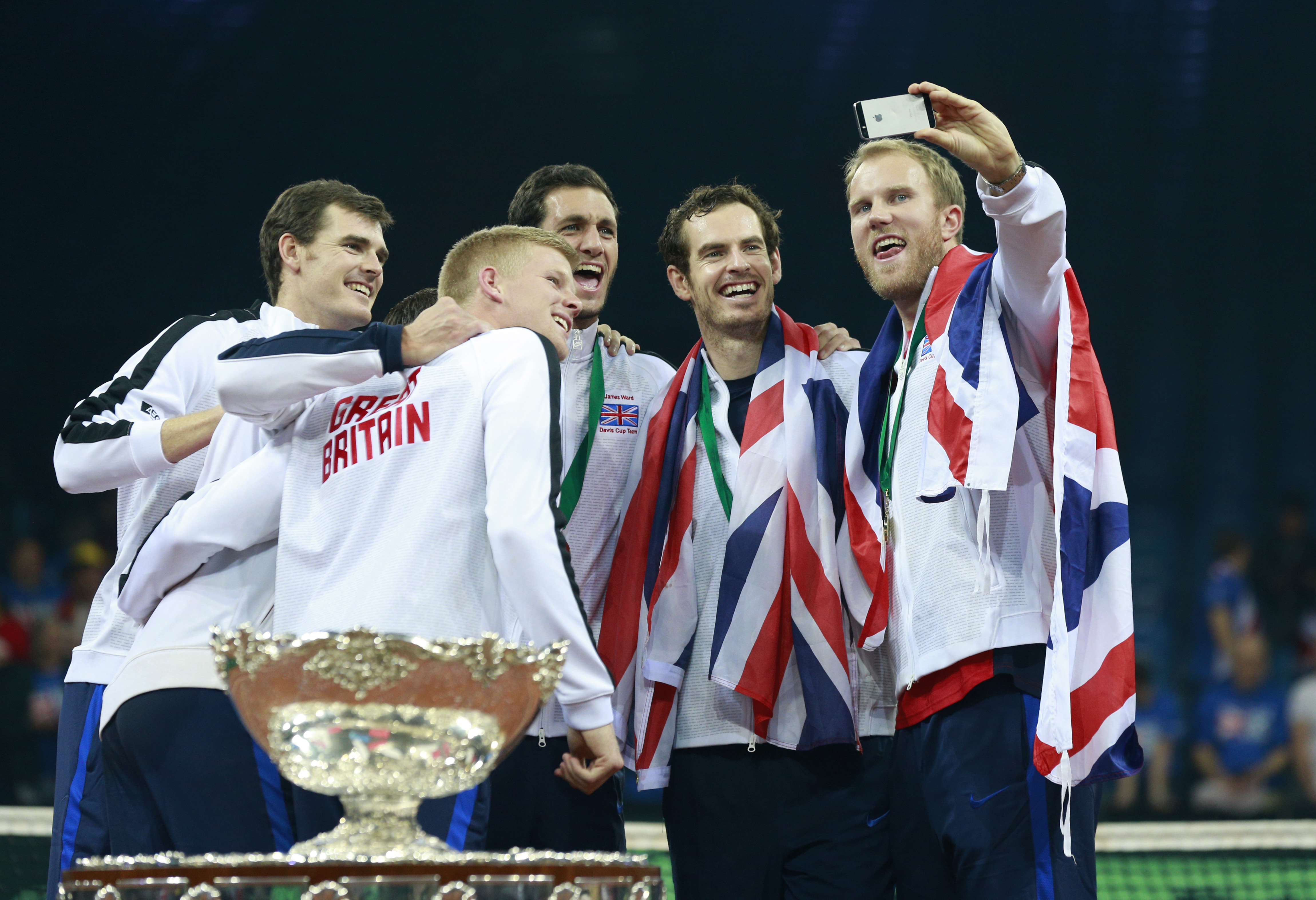 Tennis - Belgium v Great Britain - Davis Cup Final - Flanders Expo, Ghent, Belgium - 29/11/15 Men's Singles - Great Britain's Daniel Evans, Dominic Inglot, Jamie Murray, James Ward, Kyle Edmund, Andy Murray and captain Leon Smith celebrate with the trophy as they take a selfie after winning the Davis Cup Action Images via Reuters / Jason Cairnduff Livepic