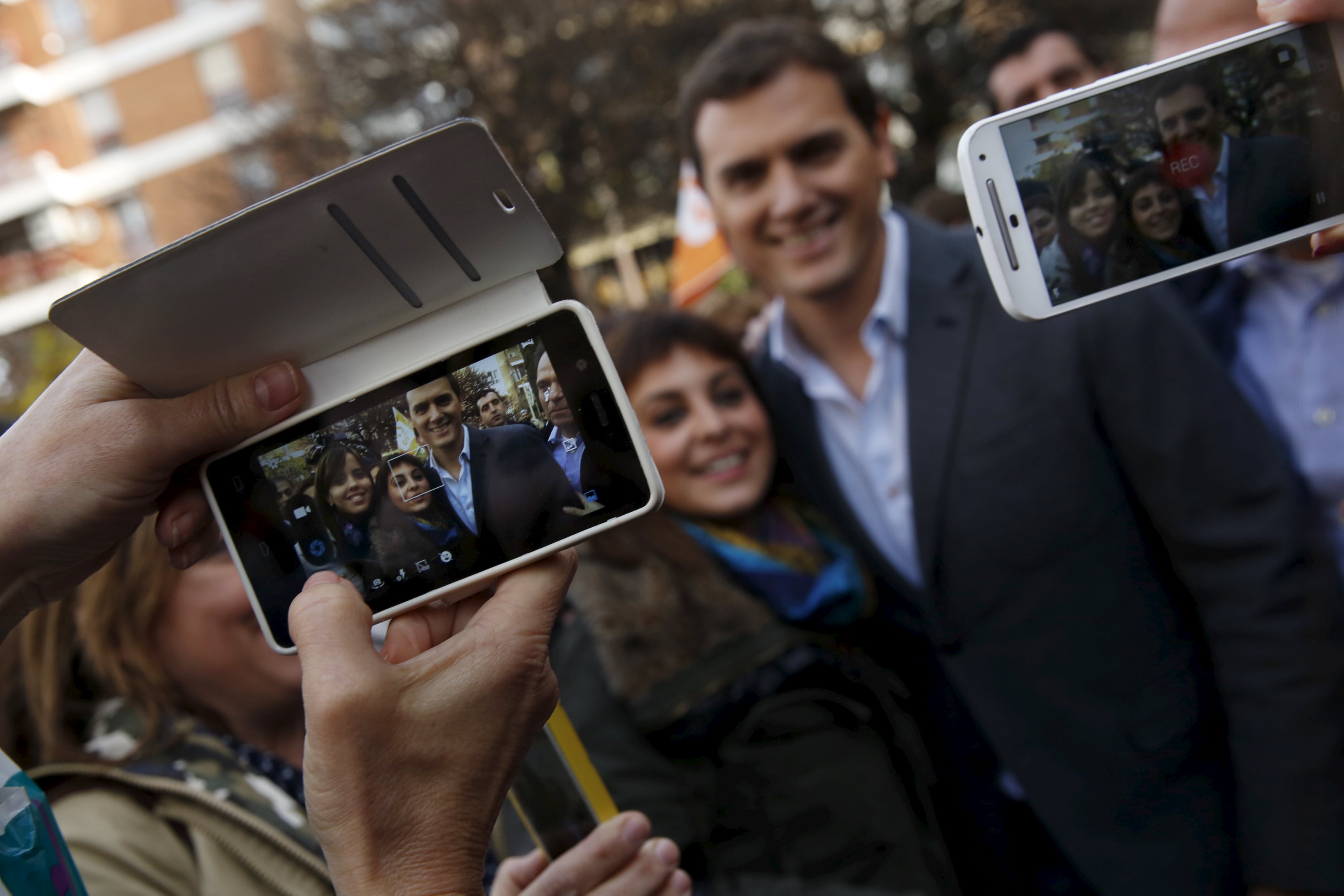 Ciudadanos party leader Albert Rivera (R), one of the four leading candidates for Spain's national election, takes a picture with a woman while on a walk on the streets of Guadalajara, Spain, December 15, 2015. REUTERS/Susana Vera TPX IMAGES OF THE DAY
