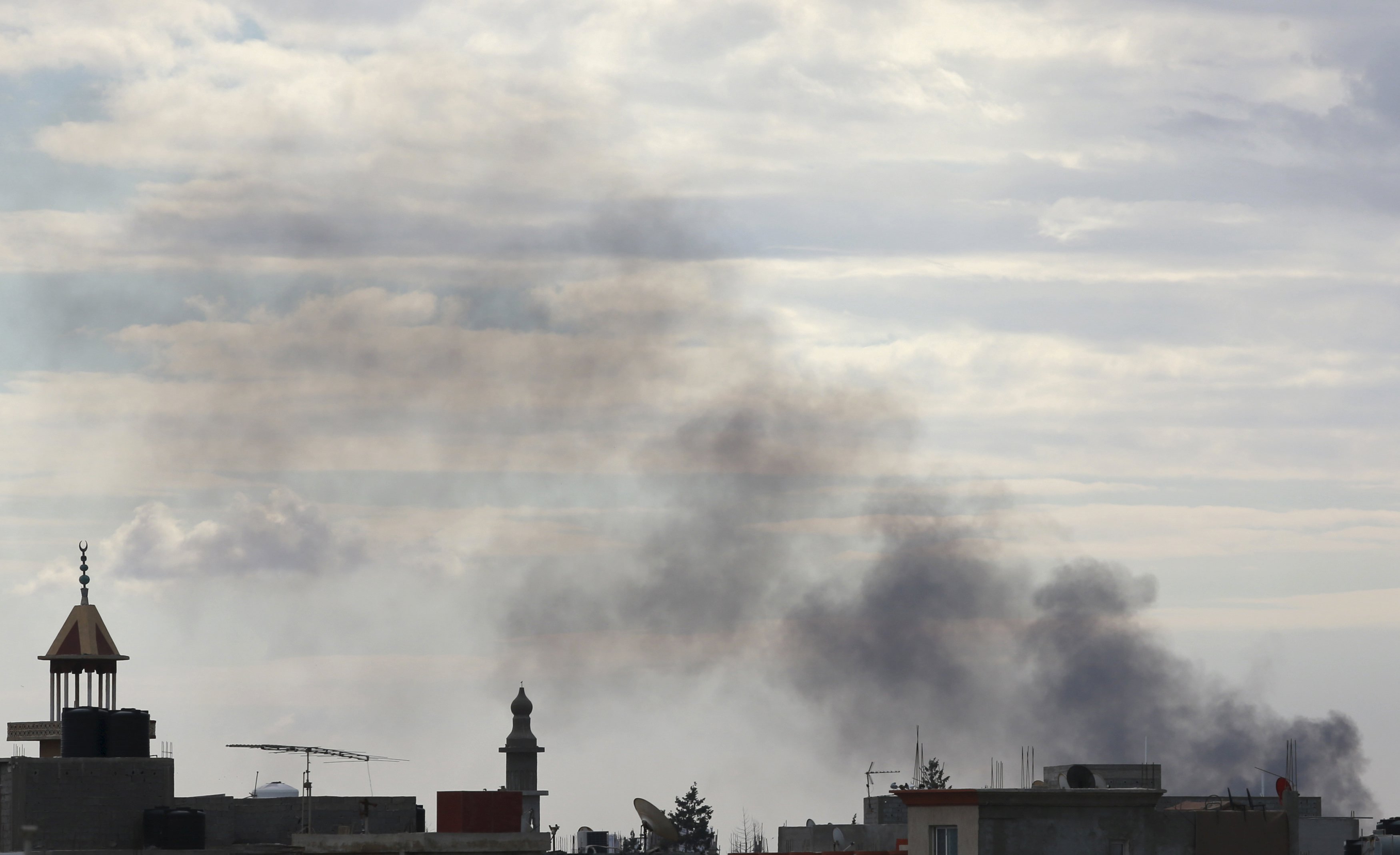 Black smoke billows in the sky above areas where clashes are taking place between pro-government forces, who are backed by the locals, and the Shura Council of Libyan Revolutionaries, an alliance of former anti-Gaddafi rebels who have joined forces with the Islamist group Ansar al-Sharia, in Benghazi, Libya December 15, 2015. REUTERS/Esam Omran Al-Fetori