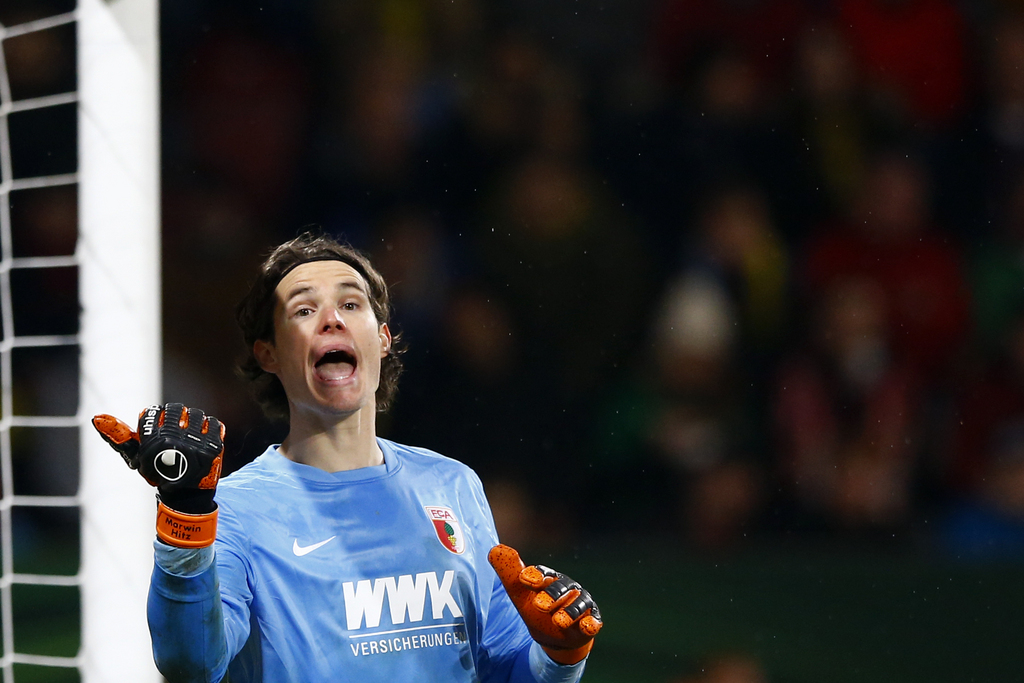 Augsburg's goalkeeper Marwin Hitz instructs his team during the German soccer cup (DFB Pokal) match between FC Augsburg and Borussia Dortmund at the WWK Arena stadium in Augsburg, Germany, Wednesday, Dec. 16, 2015. (AP Photo/Matthias Schrader)