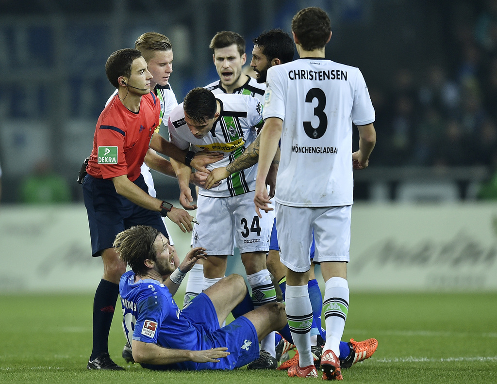 Moenchengladbach's Granit Xhaka, center, shouts at Darmstadt's Peter Niemeyer, bottom, after a foul during the German Bundesliga soccer match between Borussia Moenchengladbach and SV Darmstadt 98 in Moenchengladbach, Germany, Sunday, Dec. 20, 2015. Xhaka received the red card by referee Benjamin Brand, left, after that scene. (AP Photo/Martin Meissner)