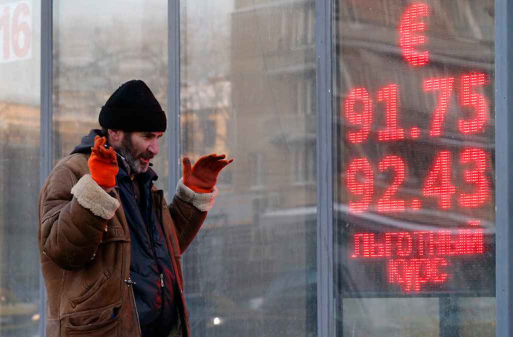 epa05116040 A Russian man passes a currency exchange office where electronic information panels display exchange rates of ruble to Euro, in Moscow, Russia, 21 January 2016. Russia&#039;s rouble currency surpassed 85 roubles per US dollar in spot trading on the Moscow Exchange bourse - beating a record low it set the previous day as prices for Russia&#039;s main export, oil, continue to tumble. EPA/YURI KOCHETKOV