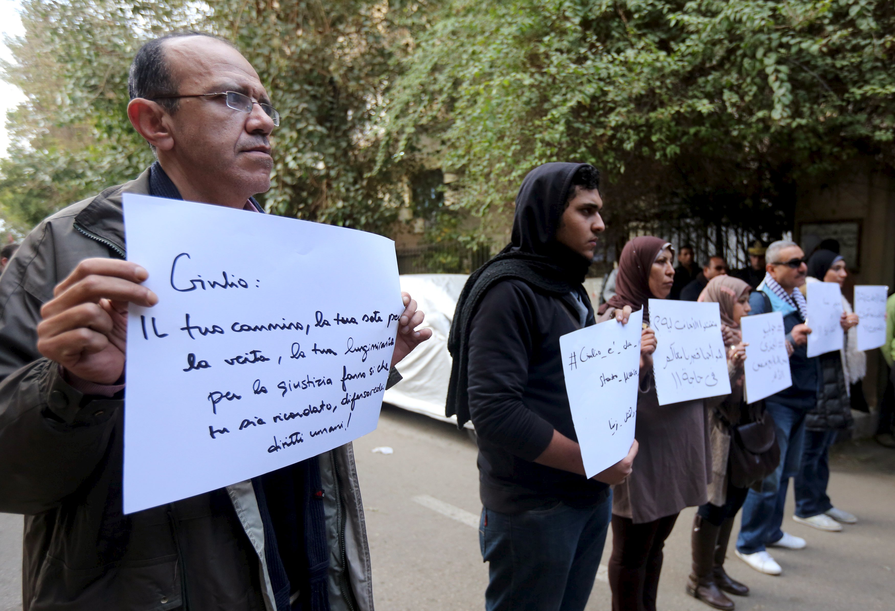 Activists hold placards that read, among others,