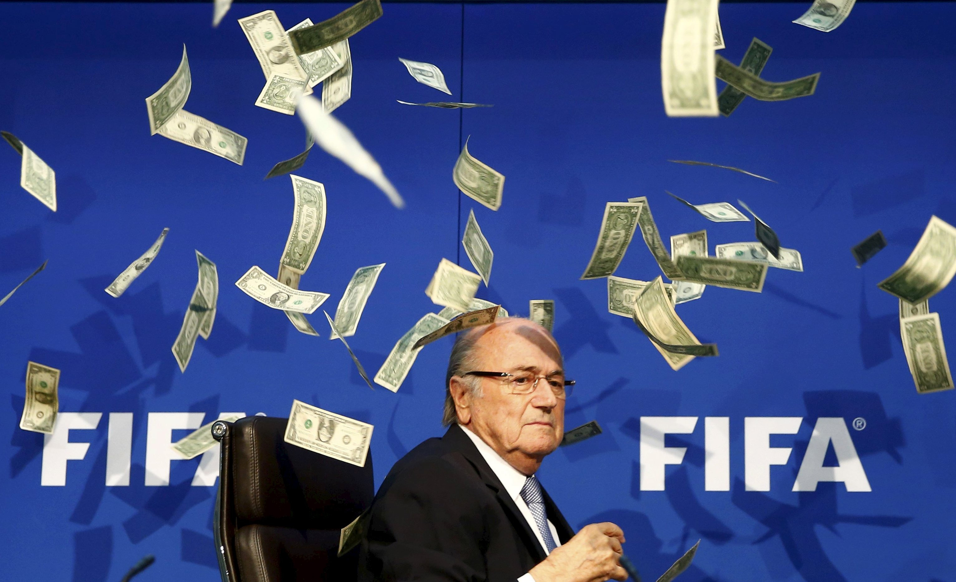 British comedian known as Lee Nelson (unseen) throws banknotes at FIFA President Sepp Blatter as he arrives for a news conference after the Extraordinary FIFA Executive Committee Meeting at the FIFA headquarters in Zurich, Switzerland in this July 20, 2015 file photo. REUTERS/Arnd Wiegmann/Files