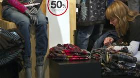 Eine Kundin sieht sich die Kleider im Ausverkauf an. Im Januar sanken die Preise für Bekleidung um 7,8 Prozent im Vergleich 
