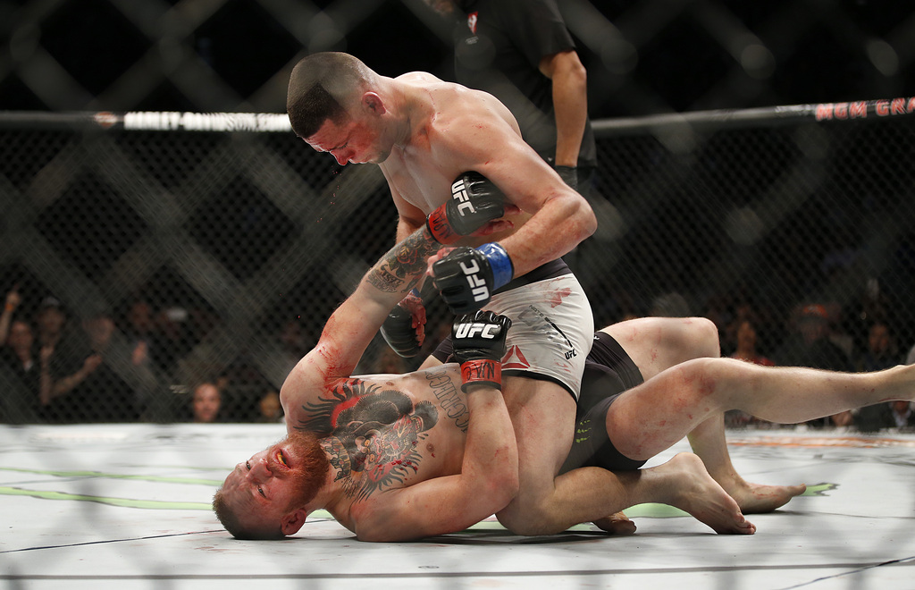 Nate Diaz, top, trades punches Conor McGregor during their UFC 196 welterweight mixed martial arts match Saturday, March 5, 2016, in Las Vegas. (AP Photo/Eric Jamison)