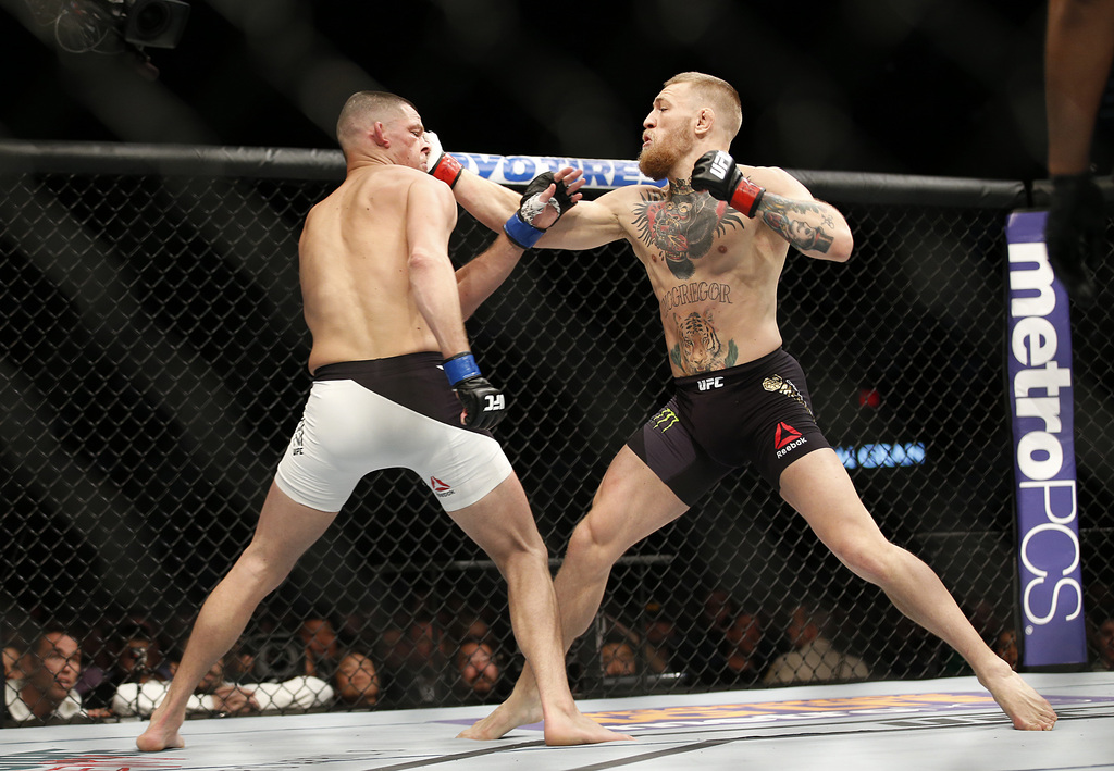Nate Diaz, left, trades punches with Conor McGregor during their UFC 196 welterweight mixed martial arts match, Saturday, March 5, 2016, in Las Vegas. (AP Photo/Eric Jamison)
