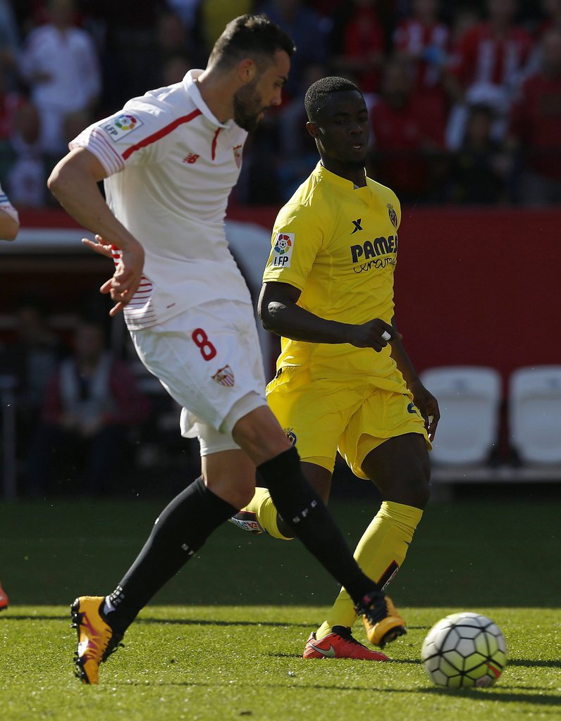 epa05209625 Sevilla's Vicente Iborra (L) kicks the ball to score in presence of Villarreal's Eric Baily, from Ivory Coast, during their Spanish Primera Division soccer match at Sanchez Pizjuan stadium in Seville, Spain, 13 March 2016. EPA/Julio Munoz