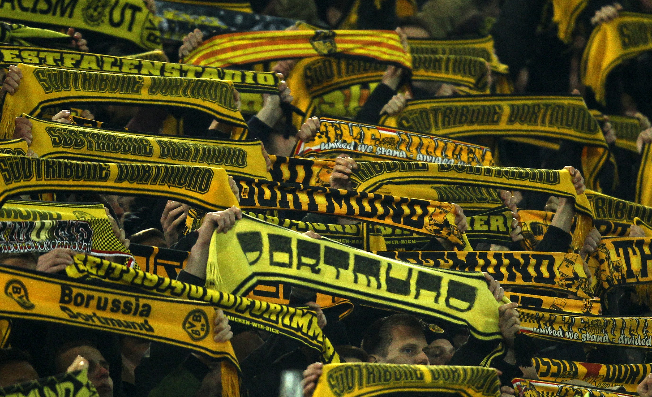 Football Soccer - Borussia Dortmund v FSV Mainz 05 - German Bundesliga - Signal Iduna Park , Dortmund, 13/03/16 Supporters of Borussia Dortmund hold on their scarves after a supporter died during the match in the stadiumREUTERS/Ina Fassbender DFL RULES TO LIMIT THE ONLINE USAGE DURING MATCH TIME TO 15 PICTURES PER GAME. IMAGE SEQUENCES TO SIMULATE VIDEO IS NOT ALLOWED AT ANY TIME. FOR FURTHER QUERIES PLEASE CONTACT DFL DIRECTLY AT + 49 69 650050