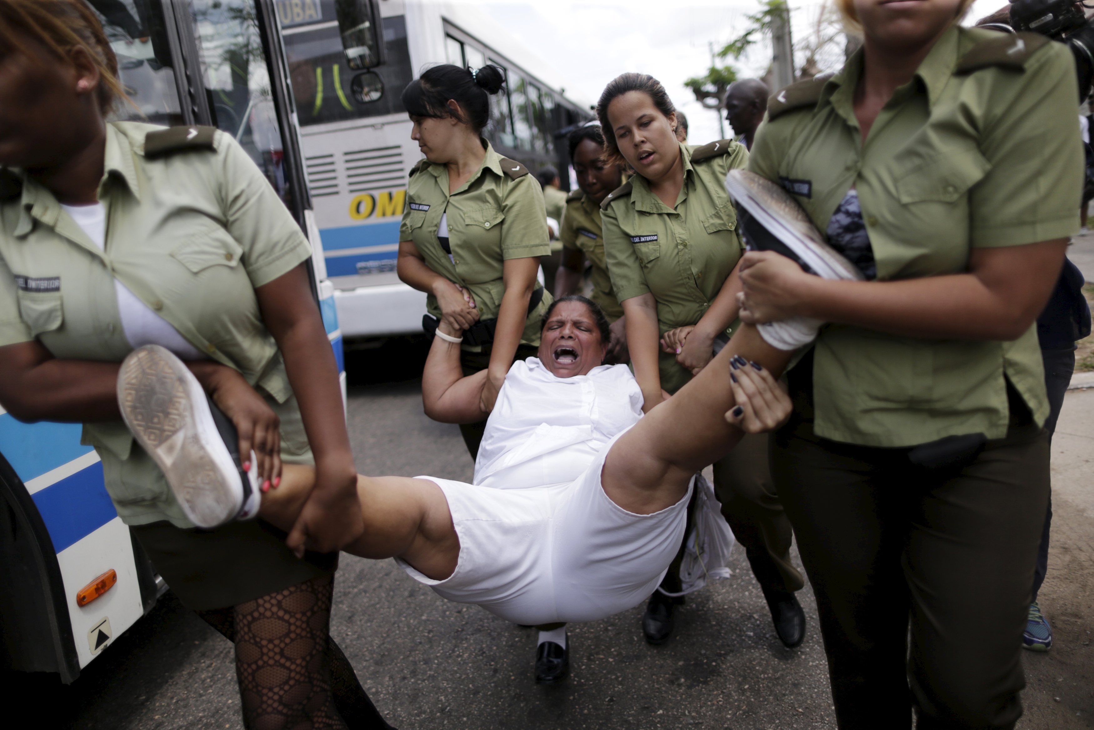 A member of the 'Ladies in White' dissident group shouts as she is carried away by police officers after they broke up a regular march of the group, detaining about 50 people, hours before U.S. President Barack Obama arrives for a historic visit, in Havana, Cuba March 20, 2016. REUTERS/Ueslei Marcelino TPX IMAGES OF THE DAY