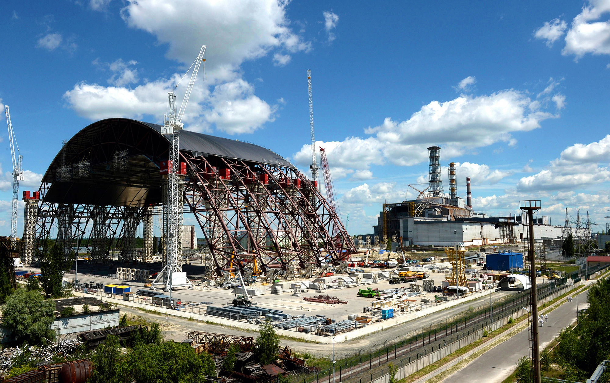 Seit Jahren wird in Tschernobyl am neuen Sarkophag (links) gebaut, der den Unfallreaktor (rechts) abschliessen soll.