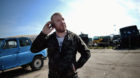 epa05238826 Bulgarian Dinko Valev (29), owner of a breakersyard for trucks and buses, uses his mobile phone while posing for 