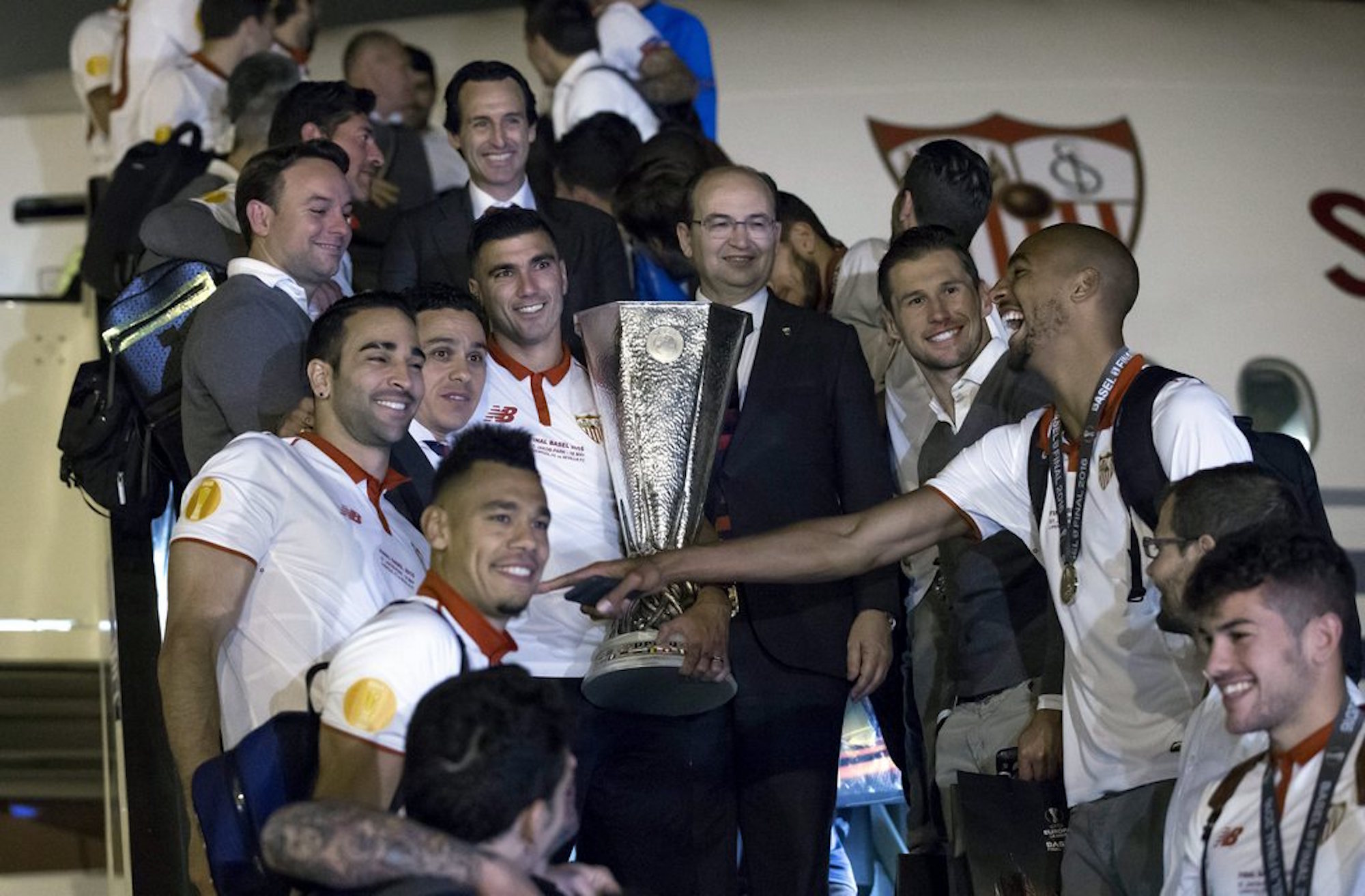 epa05315950 Sevilla FC's captain Jose Antonio Reyes (C-L) poses with the UEFA Europe League's champions trophy next to the president of the team, Jose Castro (C-R), and head coach, Unai Emery (C, rear), upon the arrival of the team to airport of Seville, southern Spain, early 19 May 2016. Sevilla FC defeated Liverpool by 1-3 in the UEFA Europe League final played at the St. Jakob-Park stadium in Basel, Switzerland, on 18 May 2016. EPA/JULIO MUNOZ