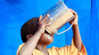 A newly arrived refugee child drinks inside their tent in Baley settlement near the Ifo extension refugee camp in Dadaab, nea