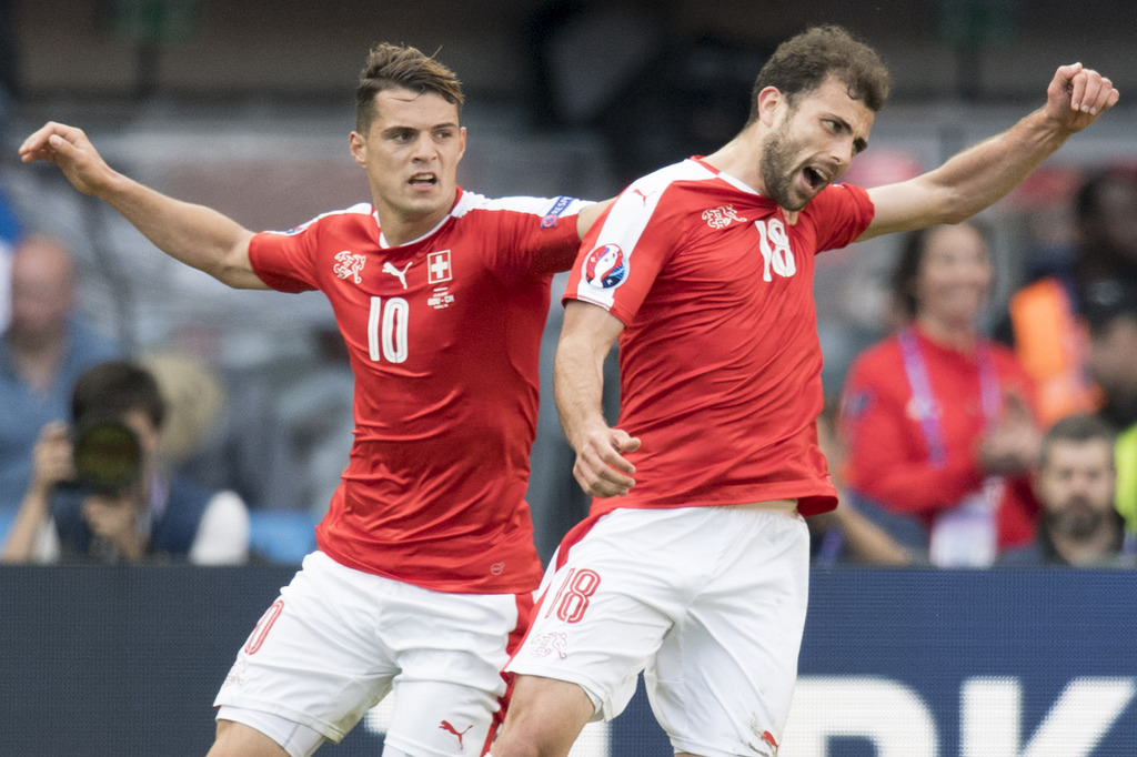 From left, Swiss soccer players Granit Xhaka and Admir Mehmedi celebrate the egalisation during the UEFA EURO 2016 group A preliminary round soccer match between Romania and Switzerland, at the Parc des Princes stadium, in Paris, France, Wednesday, June 15, 2016. (KEYSTONE/Jean-Christophe Bott)