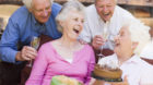 Two senior couples on patio with cake and gift smiling