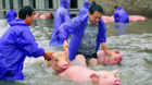 Employees save pigs from a flooded farm in Lu'an, Anhui Province, China July 5, 2016. Picture taken July 5, 2016. REUTERS/Str