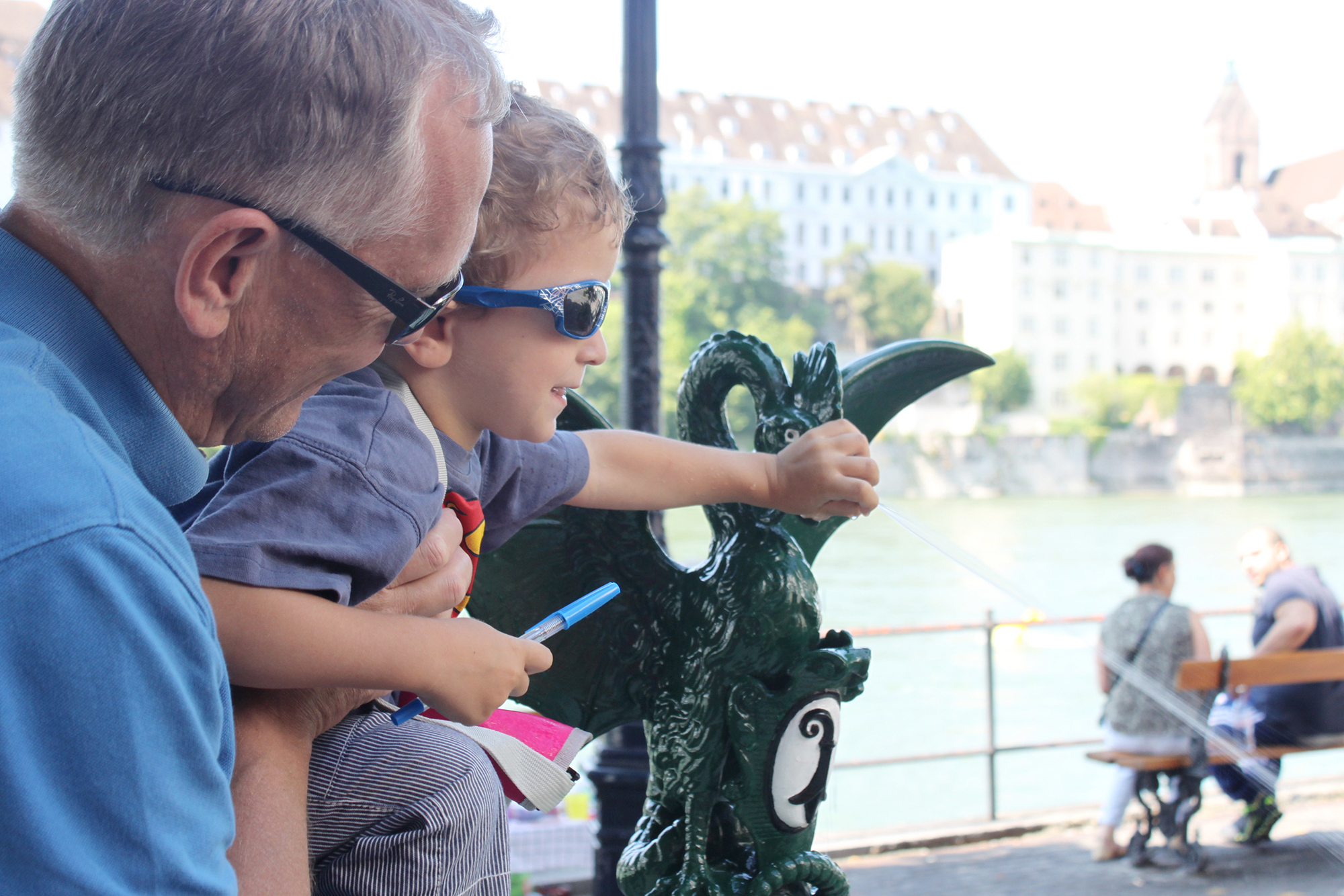Schatz-Sucher werden vom Drachen Basil durch Basel geführt – hier Vater und Sohn mit einem «richtigen» Basilisken.