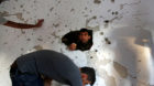 Palestinians check the damage to a house where Hamas fighter Mohammad al-Fakih was shot dead by Israeli troops during a raid 