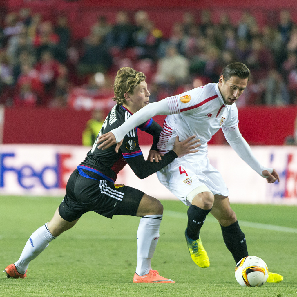 Basel's Alexander Fransson, left, fights for the ball against Sevilla's Grzegorz Krychowiak, right, during the UEFA Europa League Round of 16 second leg soccer match between Spain's Sevilla Futbol Club and Switzerland's FC Basel 1893 at the Ramon Sanchez Pizjuan stadium in Sevilla, Spain, on Thursday, March 17, 2016. (KEYSTONE/Georgios Kefalas)