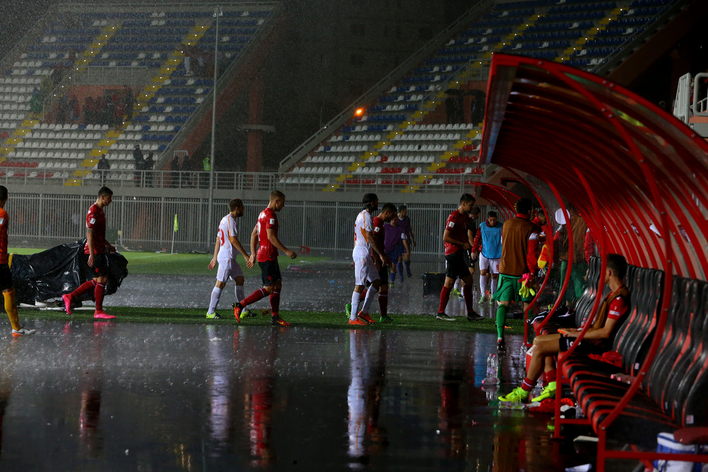 Players leave the pitch after their match was suspended due to heavy rain at the World Cup Group G qualifying match between Albania and Macedonia at the Loro Borici Stadium in Shkoder, northern Albania, Monday, Sept. 5, 2016. (AP Photo/Hektor Pustina)