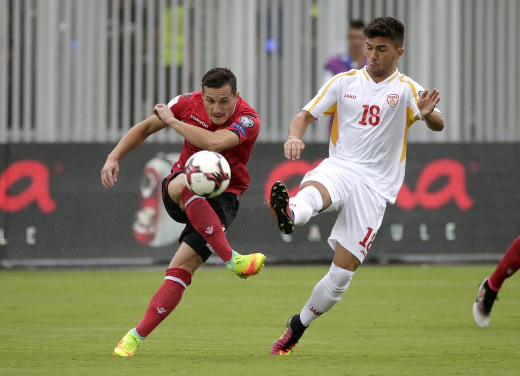 epa05527068 Albania's Taulant Xhaka (L) in action against Macedonia's Nikola Gjorgjev during the FIFA 2018 World Cup European qualifiers Group G soccer match between Albania and FYR of Macedonia at the 'Loro Borici' Stadim in Shkoder, Albania, 06 September 2016. The match was continued on 06 September after it was suspended on the previous night because of torrential rain. EPA/ARMANDO BABANI