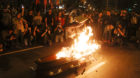 An anti-government demonstrator jumps over a coffin that represents a symbolic funeral of Brazil's President Michel Temer dur