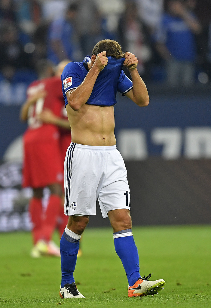 Schalke's Benjamin Stambouli, center, leaves the pitch disappointed under his shirt after losing the German Bundesliga soccer match between FC Schalke 04 and 1. FC Cologne in Gelsenkirchen, Germany, Wednesday, Sept. 21, 2016. Schalke was defeated by Cologne with 1-3. ()