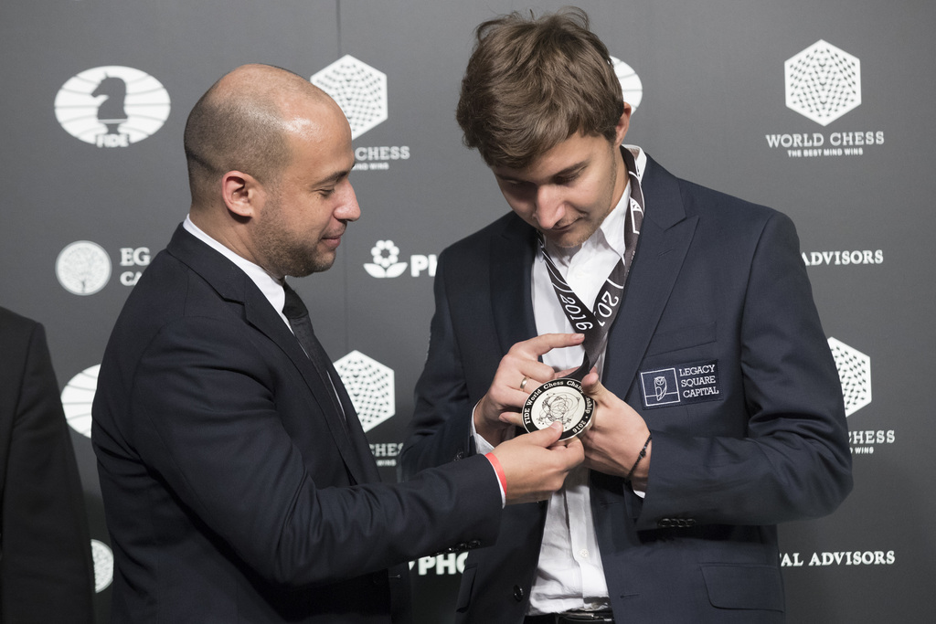 Agon's CEO Ilya Merenzon, left, presents Sergey Karjakin, of Russia, his medal during the award ceremony of the World Chess Championship, Wednesday, Nov. 30, 2016, in New York. Reigning champ Magnus Carlsen, of Norway, defeated Karjakin in the World Chess Championship in New York City. (AP Photo/Mary Altaffer)